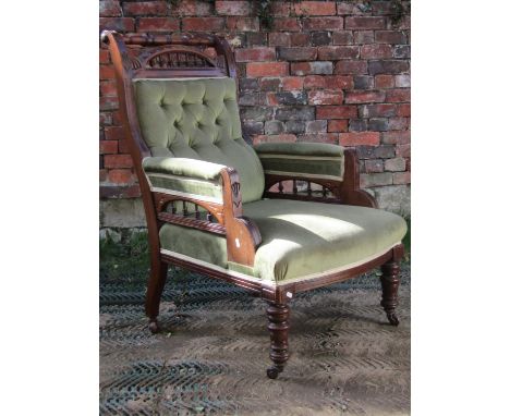 A late Victorian drawing room chair with green dralon upholstered seat, button back and arms within a walnut showwood frame w