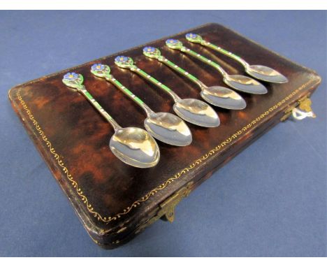 A cased set of six silver and enamel coffee spoons, the handles mounted by a daisy with alternating colours down the shank, m