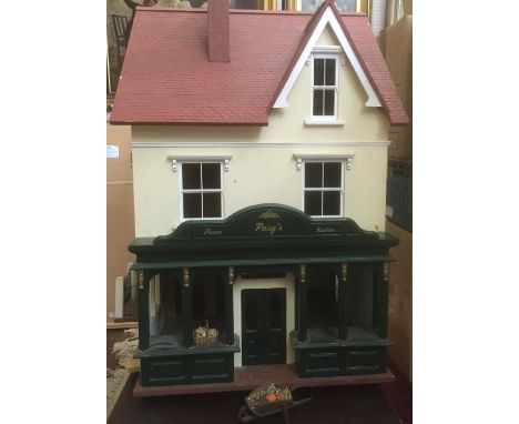 Large dolls house with attractive flower shop frontage, interior is largely unfurnished and undecorated. Hinged front, side a