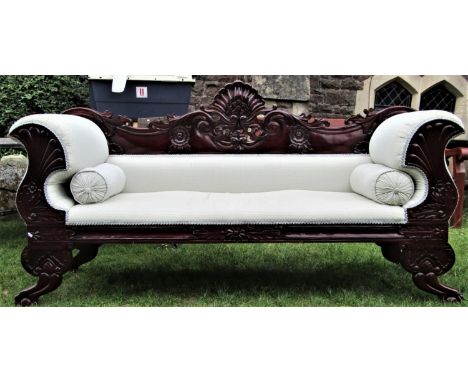 A Regency style mahogany sofa with flamboyant carved and pierced framework and upholstered finish, 2 metres wide 