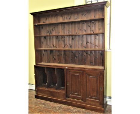 A mahogany library bookcase of full height, the lower section enclosed by two sliding doors with panelled finish and three fo