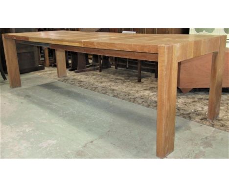 A contemporary light oak and veneered pull out extending dining table of rectangular form with two additional leaves raised o