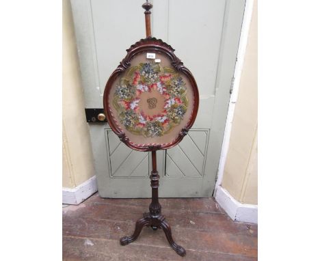 Early 19th century mahogany pole screen, the shaped framework enclosing a hand worked tapestry wool and cut steel floral garl