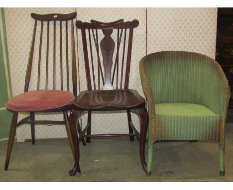 An Ercol stick back dining chair, a further Windsor style chair with saddle seat and vase shaped splat and a Lloyd Loom style