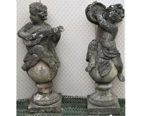 A pair of large reclaimed putti musicians, one playing the lute the other cymbals, classically draped and raised on globular 