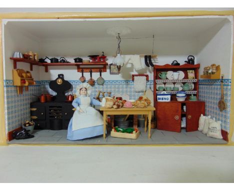 Diorama with glazed front panel (unfixed) featuring a Victorian kitchen scene with cooking range, dresser, seated cook, food,