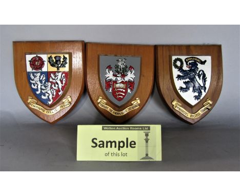 A collection of wall shields, each decorated with a polychrome crest for Royal Army Ordinance Corps, Pembroke College Oxford,