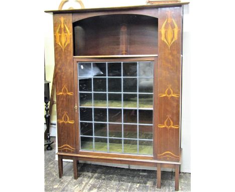 An art nouveau side cabinet with geometric marquetry panels to a central leaded light door on square tapered legs, 110cm wide