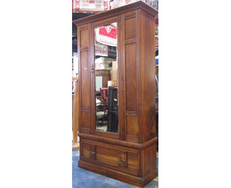 An Edwardian walnut single wardrobe, the moulded panelled front enclosed by a central three quarter length bevelled edge mirr