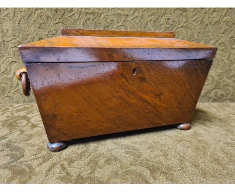 Victorian mahogany sarcophagus tea caddy with twin lidded compartments and turned ring handles and bun feet.