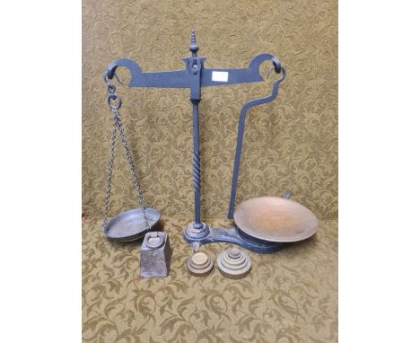 Set of wrought iron balance scales with copper pans and graduated brass weights and a 7lb ring weight. 