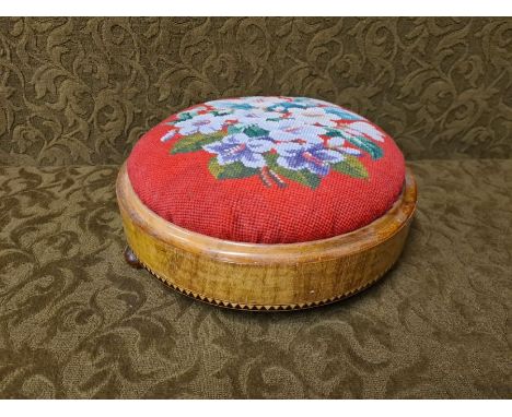 Victorian mahogany button footstool with geometric crossbanding, small bun feet and needlework top, 28cm diameter.