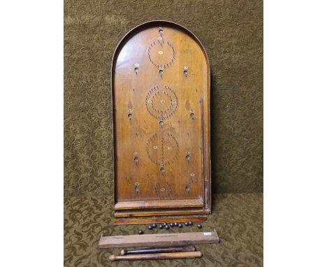 An early 20th century bagatelle board complete with balls, push sticks and riser.
