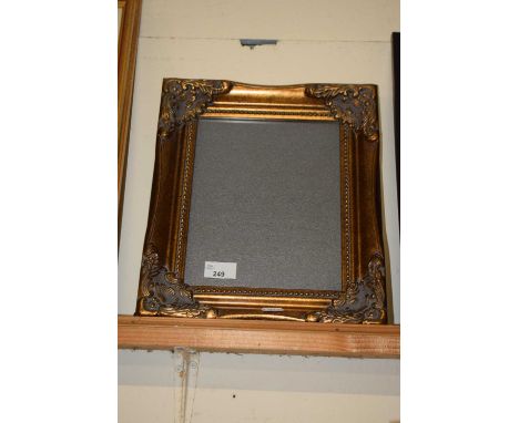 A modern gilt finish picture frame with easel back