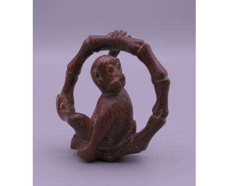 A wooden netsuke formed as a monkey. 4.5 cm high.