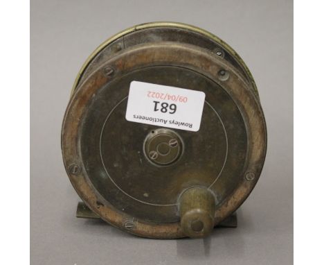 A vintage brass mounted fishing reel. 10.5 cm diameter.