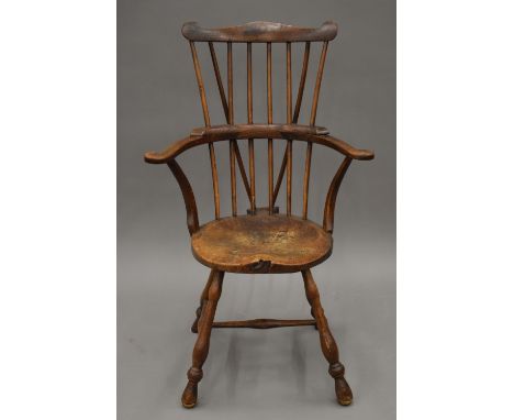 A 19th century oak stick back arm chair. 64 cm wide.