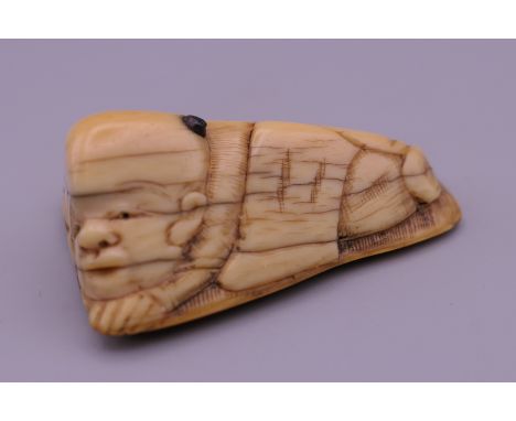 A 19th century Japanese ivory netsuke formed as a laying figure.