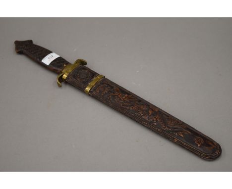 A vintage brass mounted Chinese short sword, the scabbard carved with a dragon and a phoenix. 52 cm long overall.