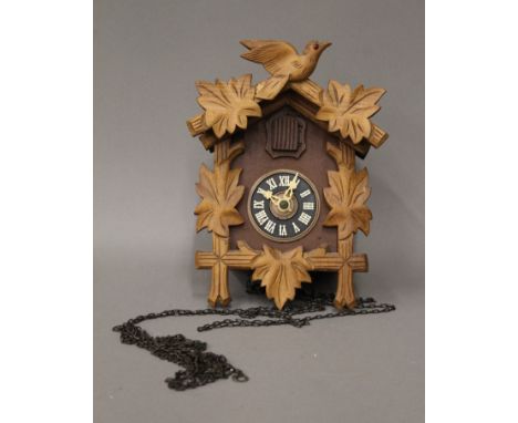 A vintage wooden cuckoo clock with two weights. 22 cm high.
