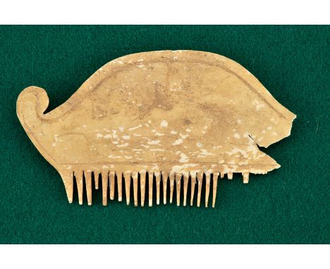 A comb dating: 800 - 400 B. C.provenance: Eastern EuropeMade of bone. Round grip chiselled with a grotesque mask and palmette