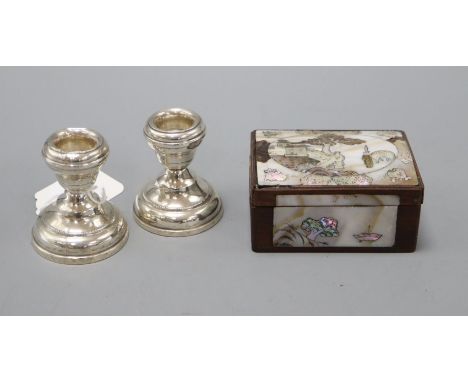 A mother of pearl snuff box and a pair of silver dwarf candlesticks