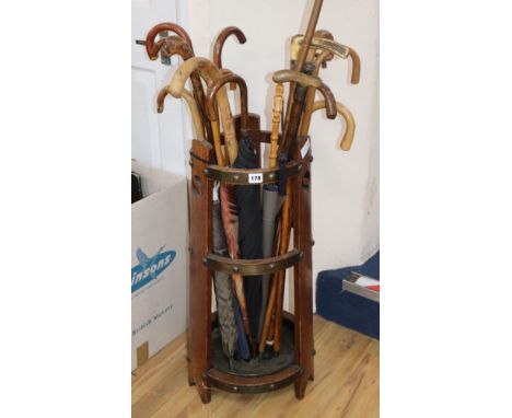 An Edwardian oak stick stand and sundry walking sticks