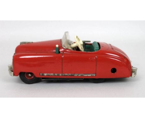 A Shuco radio controlled 4012 light red convertible with green upholstery, with keys and in good working order.