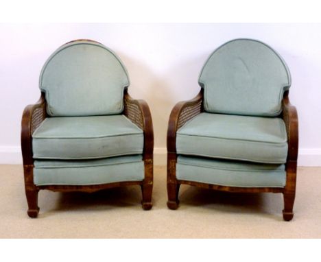 A pair of 1920's Bergere armchairs, faux walnut, with central cartouche to the backs, upholstered in light blue velour with l