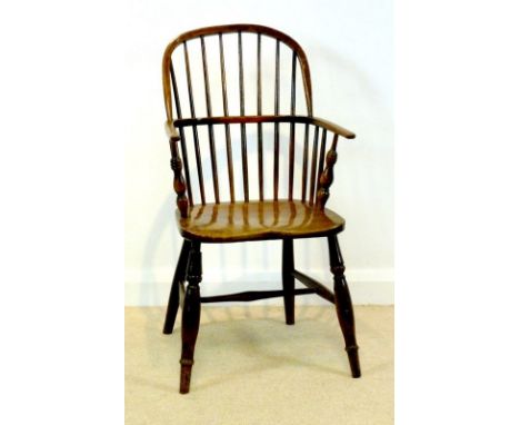 A 19th century Windsor armchair with solid elm seat and comb back, turned supports and H-stretcher, 53 by 38 by 96cm high.