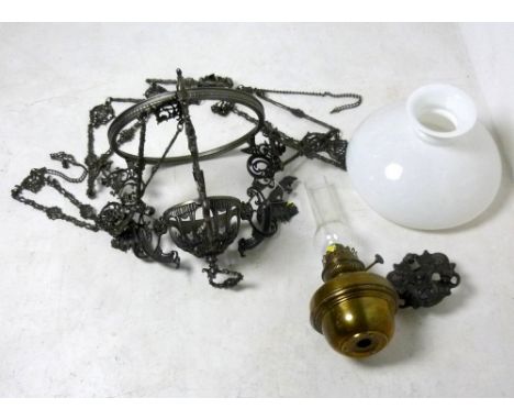 A Victorian cast iron ceiling oil lamp cast with wolves and rococo scrolls, on a triple ornate chain suspension, with brass b