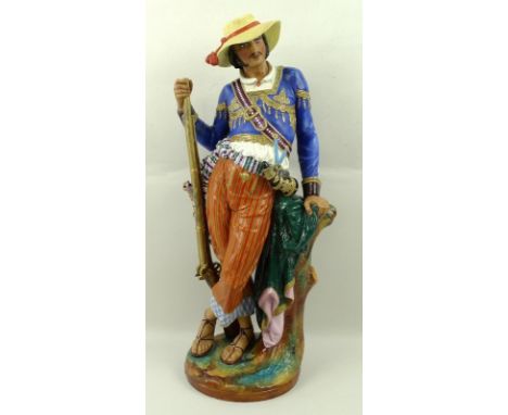 A Continental porcelain figure of a gentleman, with braided jacket, musket, shot flask and hunting bag, standing against a tr