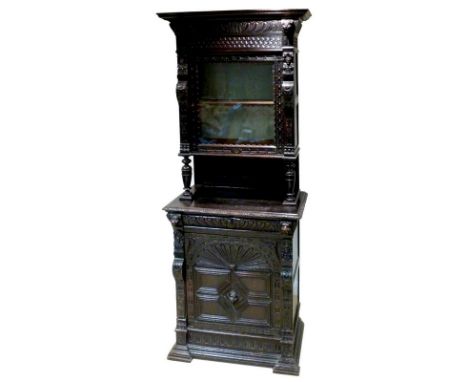 An early 19th century Dutch carved oak cupboard, with single glazed door enclosing a shelf, supported on turned baluster colu