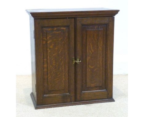 An early Victorian oak two door cupboard, with fielded panels and brass handle, single shelf, 42 by 22 by 47cm high.