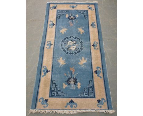 A Chinese wool rug 19th century, the central medallion with cranes to a light blue ground and a border decorated with bats, 9