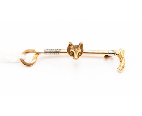 A 15ct gold hunting stick pin, as a riding crop with fox head, stamped 15ct, approx 4.6cm long, gross weight approx 5.5gms