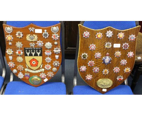 A  collection of British &amp; World Fire Brigade cap badges mounted on two wooden shields one with Derbyshire Fire Service C