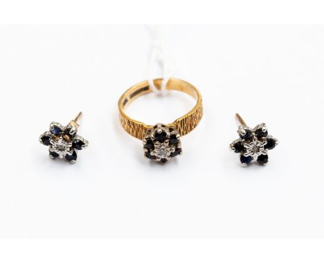 A matching diamond and sapphire ring and earrings, the ring centrally set with a diamond with sapphire surround,  bark effect