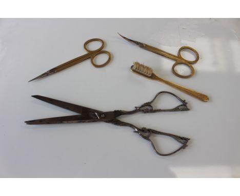 Two pairs of Asprey gilded dressing table scissors with engine turned decoration, together with a matching brush, and a pair 