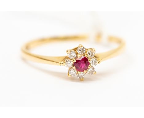 A ruby gold diamond small cluster ring, the central round ruby with a claw set diamond surround, diameter approx 5mm, 18ct go