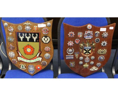 A collection of British &amp; World Fire Brigade cap badges mounted on two wooden shields with Derbyshire Fire Service Coat o