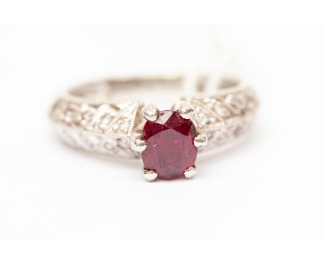 A ruby and diamond set dress ring, the oval claw set ruby approx 0.75ct, with angled shoulders set with double rows of brilli