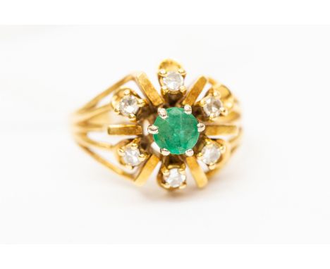 An 18ct. gold, diamond and green stone cluster ring, having raised centre to the mount set round-cut emerald surrounded six r