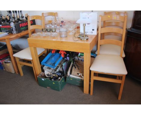 An oak extending dining table with a set of four ladder back dining chairs