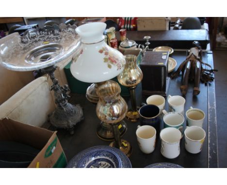 A glass bowl raised on figural base; together with an oil lamp with shade; two candle holders and a quantity of mugs