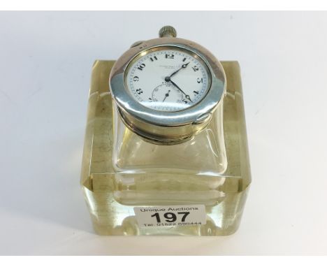 A glass inkwell with silver topped pocket watch holder incorporating a steel cased watch, marked Hardy Bros. Ltd. London.