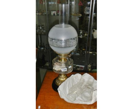 An oil lamp with 2 spare glass chimneys