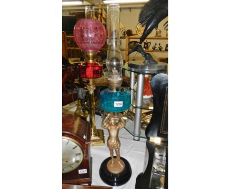 A Victorian spelter figure oil lamp with blue glass font