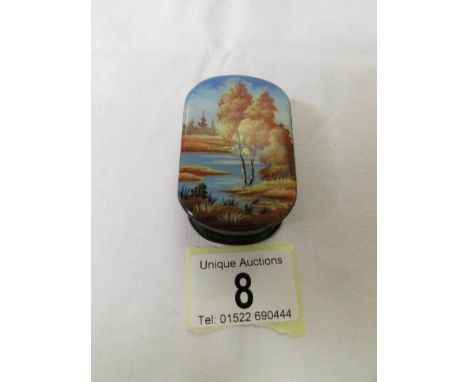 A signed Russian lacquered snuff box depicting a hand painted lake scene.