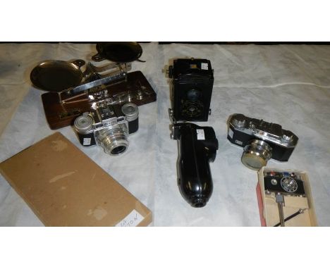 An Eastman chemical scales, a photo lite camera lighter, a Voigtlander camera, a Braun 35mm Super Paxette and a Halina 35 mm.